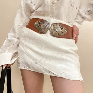 Détail d'une ceinture marron vintage avec boucles baroques en forme de cœur sur mannequin