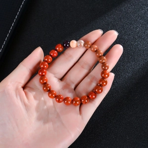 Close-up of Eight Planets natural stone beaded bracelet with glossy finish on hand