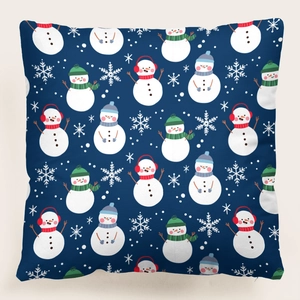 Detalle de funda de cojín navideño con motivos de muñecos de nieve y copos sobre tela azul
