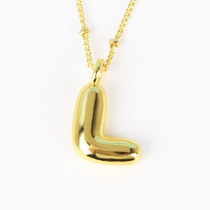 Close-up of a 3D bubble letter L pendant in polished gold on a delicate bead chain