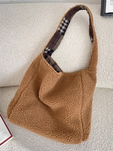 Brown plush tote bag with plaid lining on a cozy sofa, large winter shoulder bag