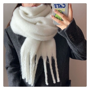 Detail view of soft white mohair scarf with plush texture and long fringe tassels