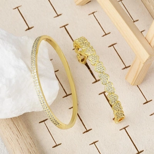 Elegant gold plated heart shaped bracelets with sparkling cubic zirconia on a rustic display