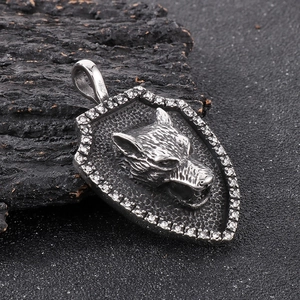 Detail view of a vintage silver wolf head shield pendant with sparkling rhinestones