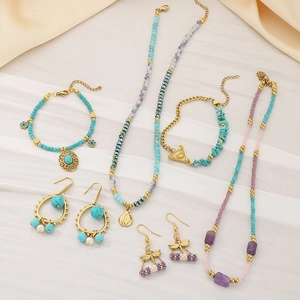 Flat lay of bohemian turquoise jewelry set with necklaces and earrings on silk