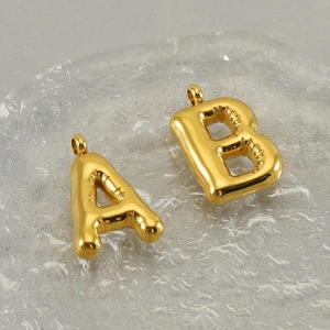 Detailed macro view of gold-plated puffy balloon A and B letter pendant charms