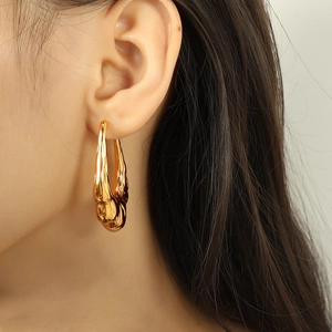 Chic 18K gold plated titanium steel earrings with abstract hollow lava design on model