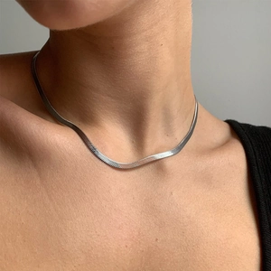 Close-up of a 3mm silver herringbone chain necklace on a model's neck for elegant style