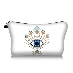 Detailed close-up of white evil eye makeup bag with gold zipper on white background