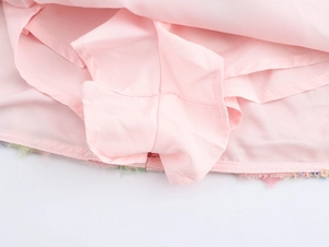 Detaillierte Nahaufnahme des glatten rosa Polyesterfutters und der feinen Nähte am Minirock