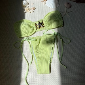 Flat lay of light green ribbed bikini with gold starfish buckle and side-tie bottoms