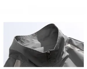 Detail of color-block jacket collar featuring high-neck zipper and reflective fabric