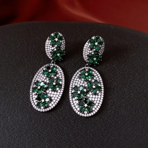Close-up of vintage flower earrings with emerald green and white zircon stones