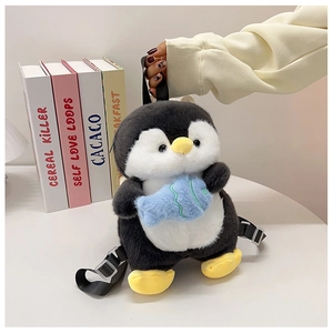Detail of plush penguin backpack with adjustable straps and blue fish accessory