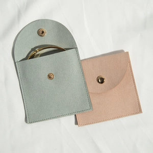 Detailed view of mint green and dusty pink microfiber jewelry pouches with gold snaps