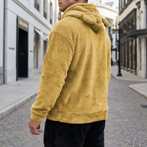 Detail of yellow plush hoodie featuring decorative animal ears on the hood back