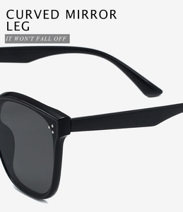 Detail shot of the curved mirror leg design on sleek black square sunglasses