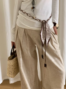 Détail de ceinture en foulard bohème avec perles en bois sur pantalon large en lin