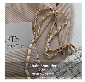 Detailed macro of the gold chain shoulder strap and white tweed fabric on the handbag