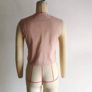 Detailed back view of the pink asymmetrical sleeveless vest on a display mannequin