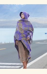 Detail of purple ethnic hooded poncho with geometric patterns and black tassels on edge