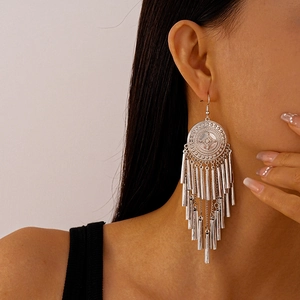 Close-up of vintage silver geometric earrings with long cascading metal fringe on model