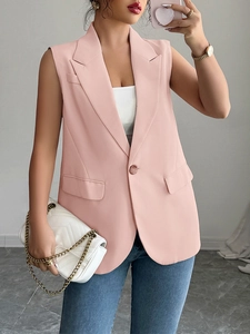 Detailed view of an elegant pink sleeveless waistcoat blazer for women with a white chain bag