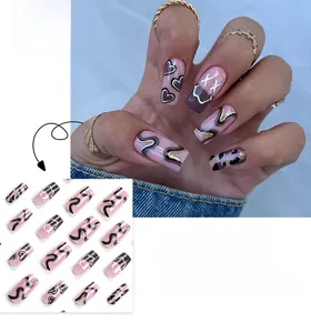 Detail of pink press-on nails featuring black waves, leopard heart motifs, and gold glitter