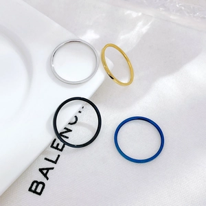 Set of four minimalist polished stainless steel rings in silver, gold, black and blue