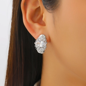 Macro shot of silver-tone flower ear cuff with sparkling marquise zircon on ear