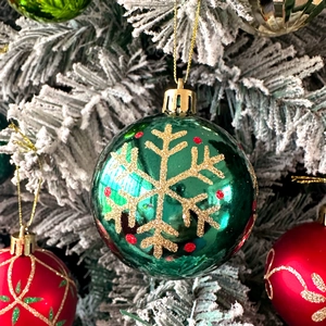 Macro shot of 6cm red and green Christmas ornaments with snowflake patterns and gold glitter