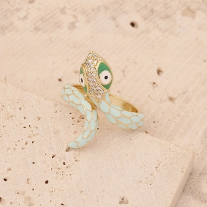 Macro shot of gold snake ring with light green enamel scales and sparkling crystals