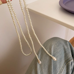 Détail du long collier de perles avec des pendentifs baroques en forme de goutte d'eau