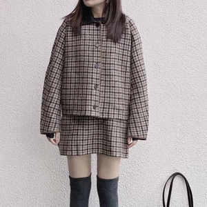 Dettaglio del set in tweed a quadri marrone e nero, trama del tessuto e dei bottoni