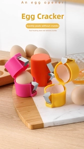 Manual egg shell opener tools in colorful plastic and steel shown on a wooden board