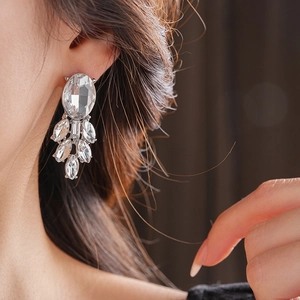 Details von silbernen Ohrringen mit Marquise-Kristallen an einem eleganten Model