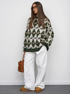 Detail of knit sweater with green argyle pattern and equestrian horse jacquard design