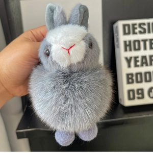 Close-up of fluffy grey and white rabbit plush keychain with soft fur and cute eyes