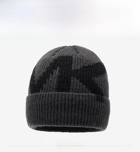 Close-up of ribbed knit beanie texture with large letter pattern and woven side label