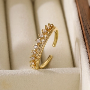 Macro detail of a gold crown ring with zircons set in a beige velvet jewelry box