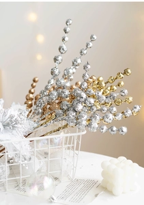 Macro shot of glittery gold and silver Christmas berry stems in a white basket décor