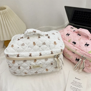 Close-up of quilted cosmetic bags with cute teddy bear and cat patterns and dual zippers