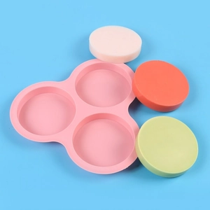 Pink 3-cavity silicone round cake mold tray with samples on a blue background