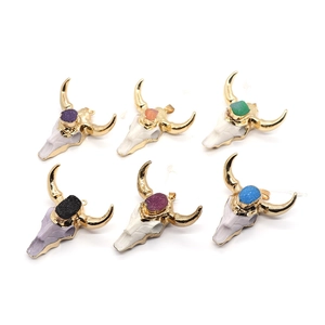 Set of six bull skull pendants in gold finish with colorful crystals on white background
