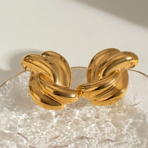 Boucles d'oreilles nœuds en acier inoxydable plaqué or 18k sur plateau en verre