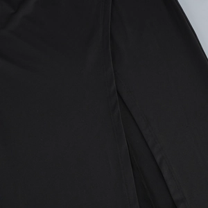 Detailed close-up of the black dress fabric texture and professional slit stitching
