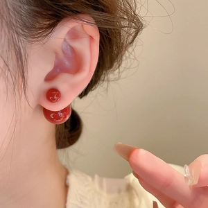 Elegante kirschrote Doppelperlenohrringe mit Hochglanzfinish am Modellohr