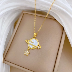 Detail of Saturn pendant with white shell and sparkling diamonds on a silk background