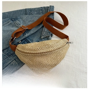 Mini straw woven waist bag with brown canvas strap and zipper closure shown with phone