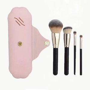 Portable pink silicone makeup brush case with four black brushes for travel and storage
